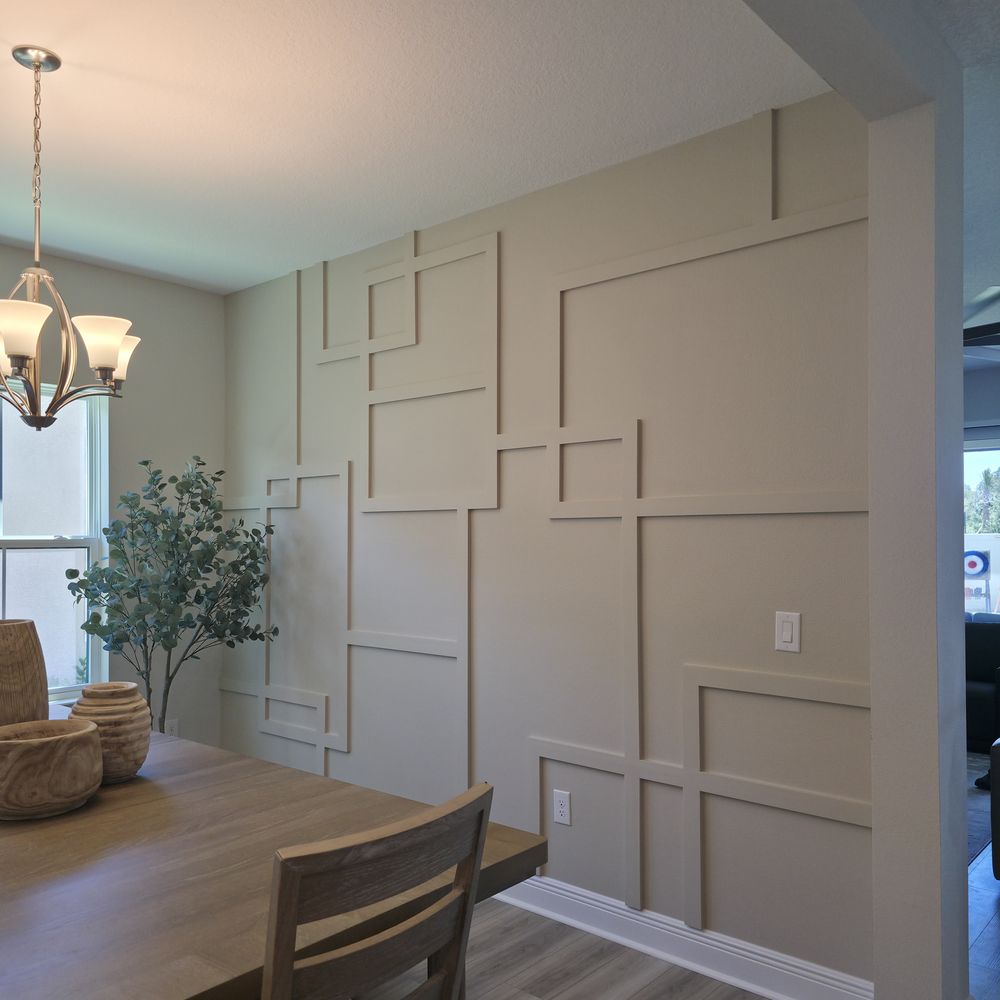 Custom trim accent wall in a dining room by Renovari