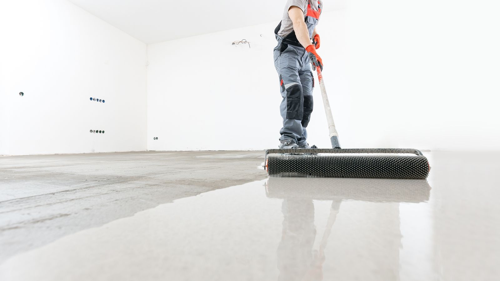 Worker rolling a coating onto a concrete floor