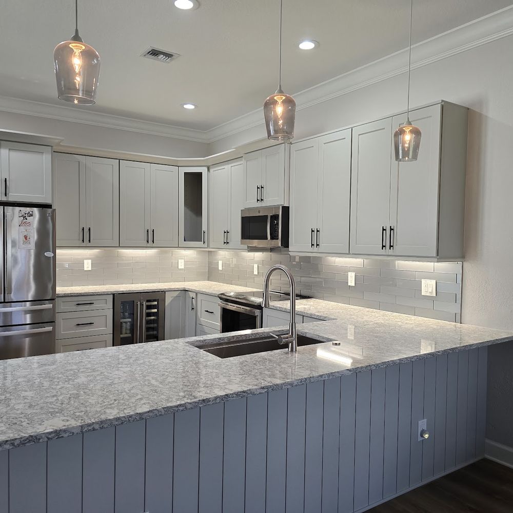 Kitchen cabinets painted white with gray island by Renovari