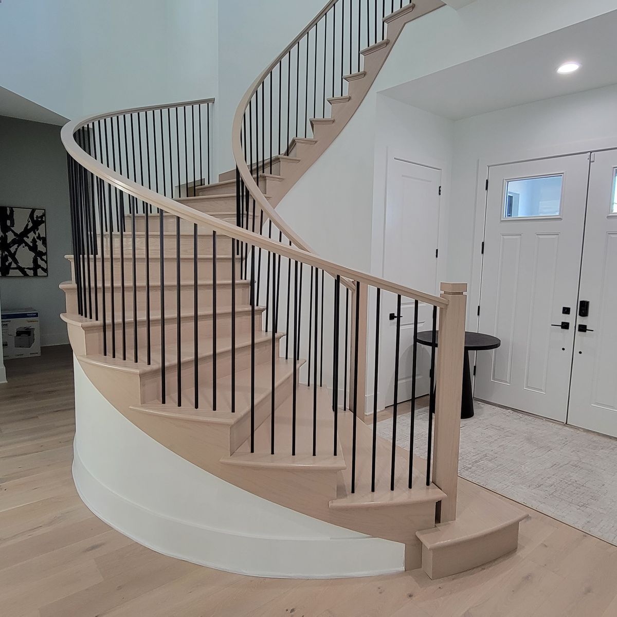 Curved staircase with wood treads and painted finish by Renovari