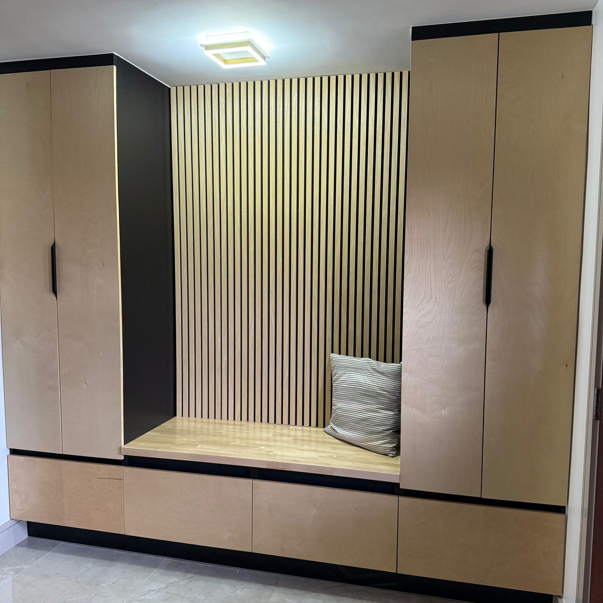 Custom entry built-in with bench and wood slat back by Renovari