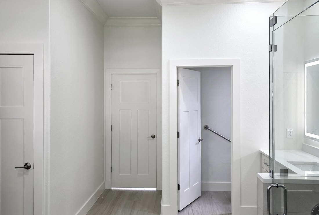 Hallway with interior doors, casings and baseboards painted white by Renovari