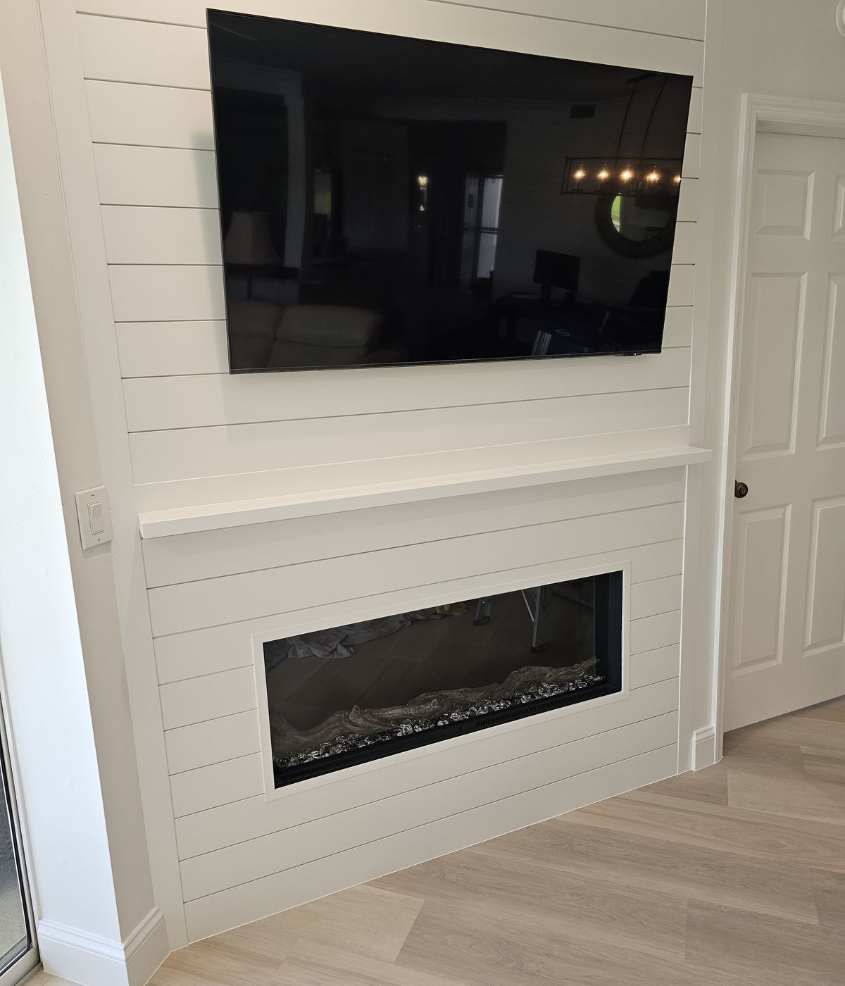 Shiplap fireplace and TV wall built and painted by Renovari