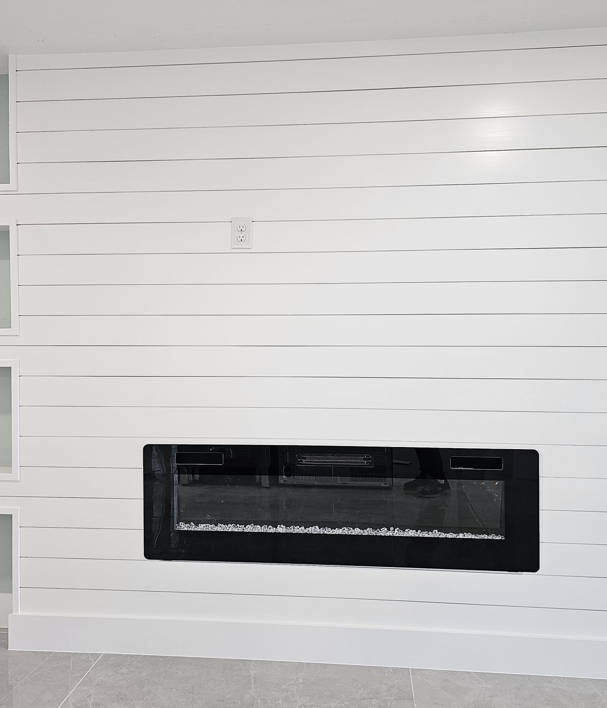 White shiplap fireplace wall with built-in niches by Renovari