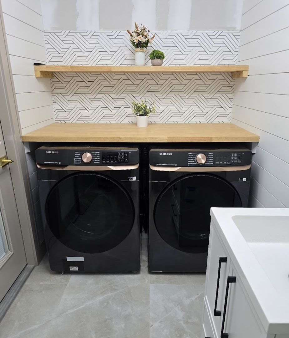 Laundry room with shiplap wall and wood shelves by Renovari