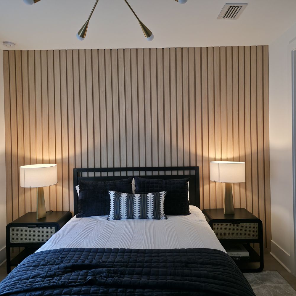 Wood slat accent wall in a bedroom by Renovari
